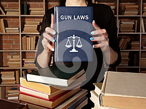 GUN LAWS book in the hands of a lawyer. Gun control is one of the most divisive issues in AmericanÃÂ politics photo